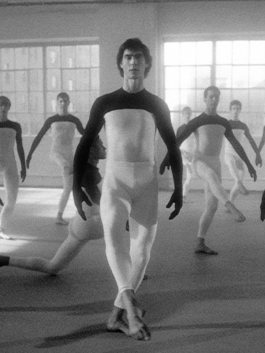A group of men in white and black leotards

Description automatically generated