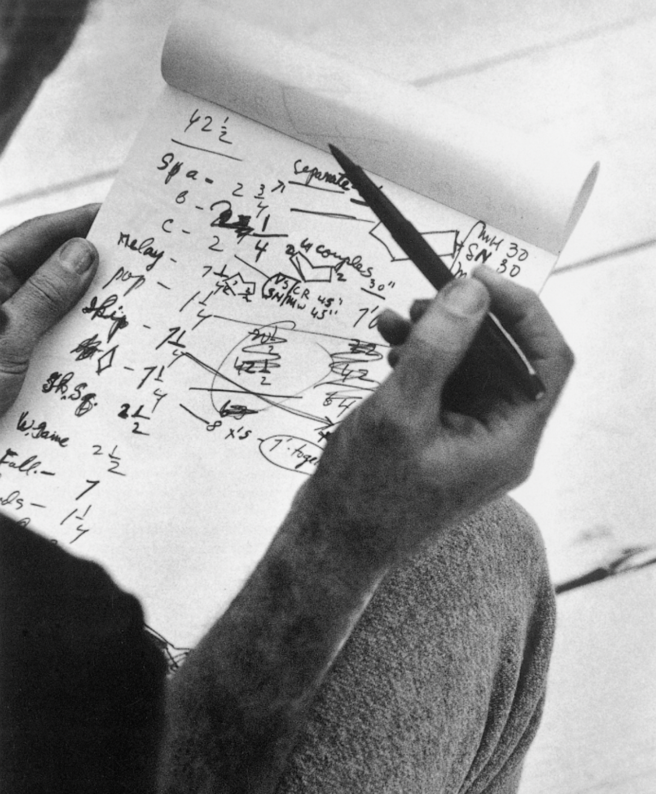 A person writing on a piece of paper

Description automatically generated