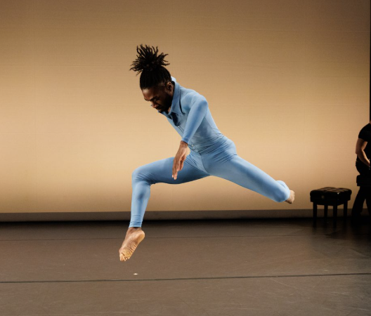 A person in blue jumpsuit jumping in mid air

Description automatically generated
