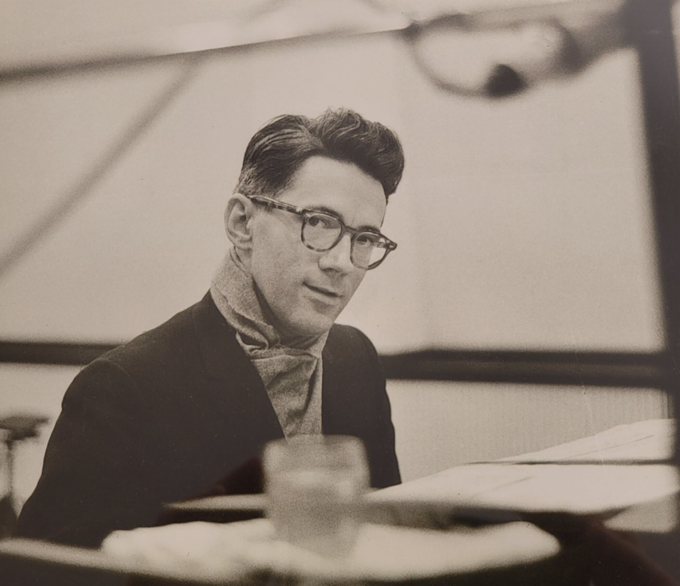 A person wearing glasses and a scarf sitting at a table

Description automatically generated